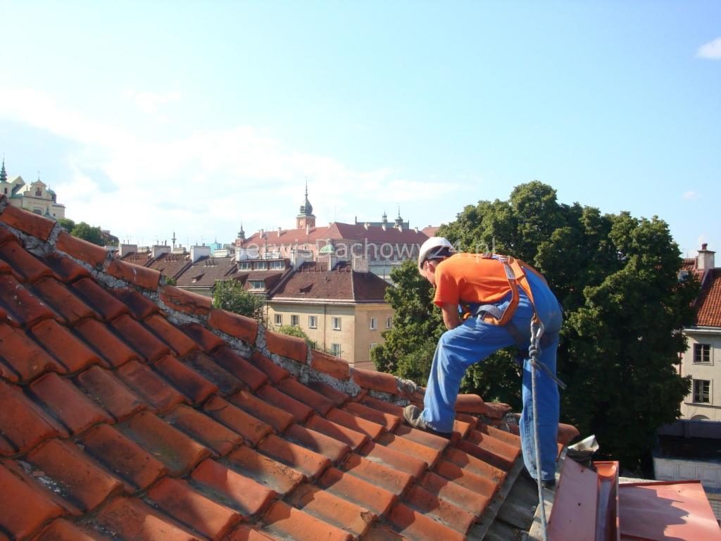 Dekarz na dachu kamienicy na Starym Mieście