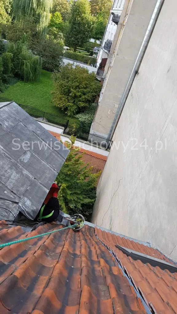 Dekarz na dachu płaskim przy zakładzie przemysłowym