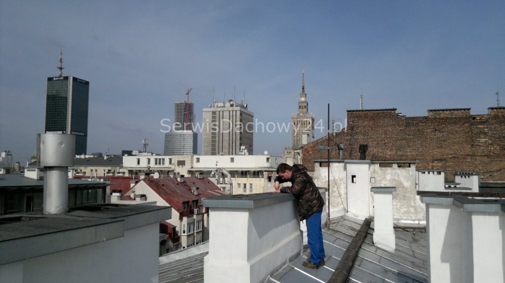 Przegląd dachu kamienicy w centrum Warszawy, w tle Pałac Kultury